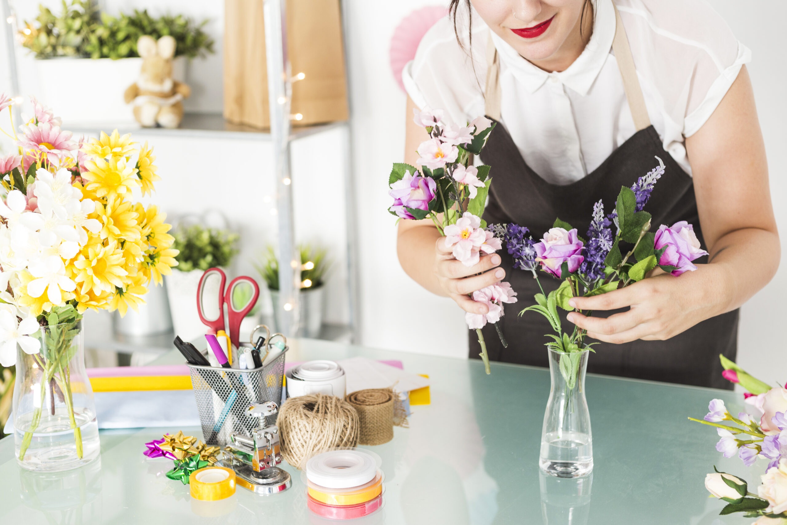 mulher-por-flores-em-vaso-ligado-escrivaninha-vidro
